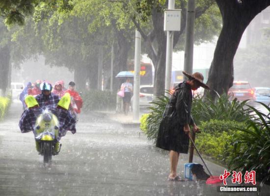 6月16日，广西柳州市遭暴雨侵袭，一名清洁工在雨中扫地。记者 朱柳融 摄