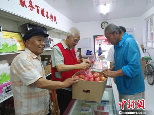 针对小区居民老人居多、出门购物不便的状况，老党员、志愿者每天义务去市场批发日常生活用品，回到小区平价卖给小区居民。图为红巾社区80多岁志愿者卖菜给小区居民。　赵桂华 摄