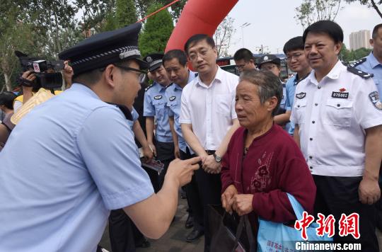 图为治安警察向民众现场讲解如何防范电信诈骗和非法集资。　宋寿涛 摄