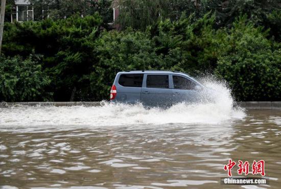 7月16日，长春迎来暴雨天气，市区多处出现内涝积水。图为车辆在水中行驶。 张瑶 摄